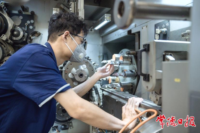 湖南中烟常德卷烟厂操作工进行设备保养。通讯员 夏昕睿 摄