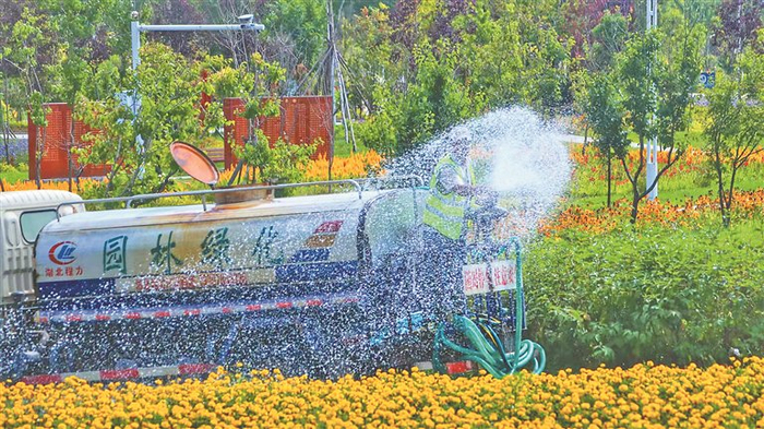     环卫工人为绿化带浇水。资料片