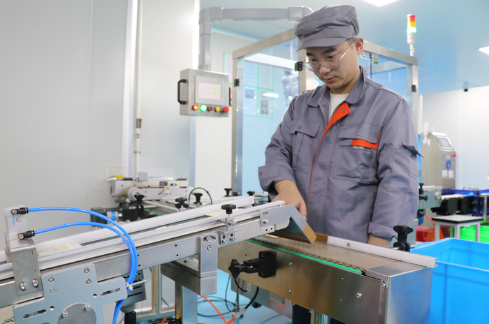 位于浙江省德清县的浙江润和生物科技有限公司工人正在检查贴标机传输带运作情况。（资料图片）