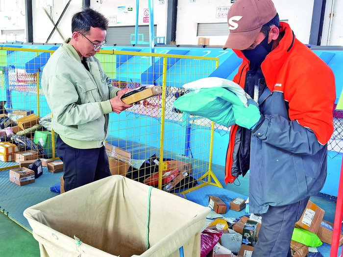 万玛尖措（左）整理分拣好的快递包裹。