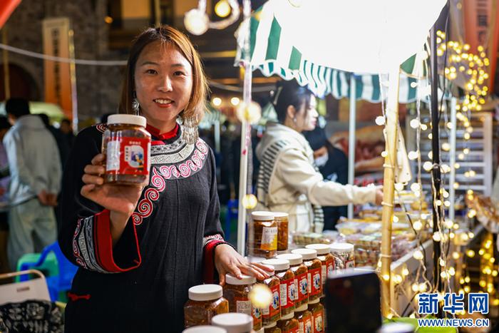 售卖民族特色食品的卖家在展示产品（11月23日摄）。新华网发（陶家淇 摄）