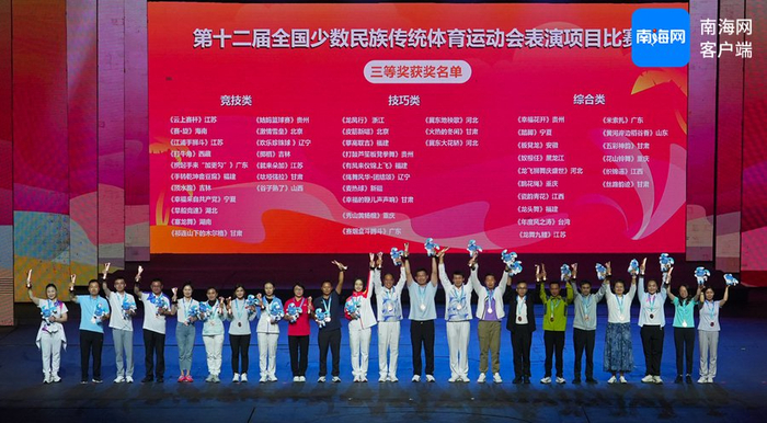 第十二届全国少数民族传统体育运动会表演项目颁奖晚会在海南三亚举行，获得第三名的代表团在领奖。海报集团全媒体记者 汪承贤 摄