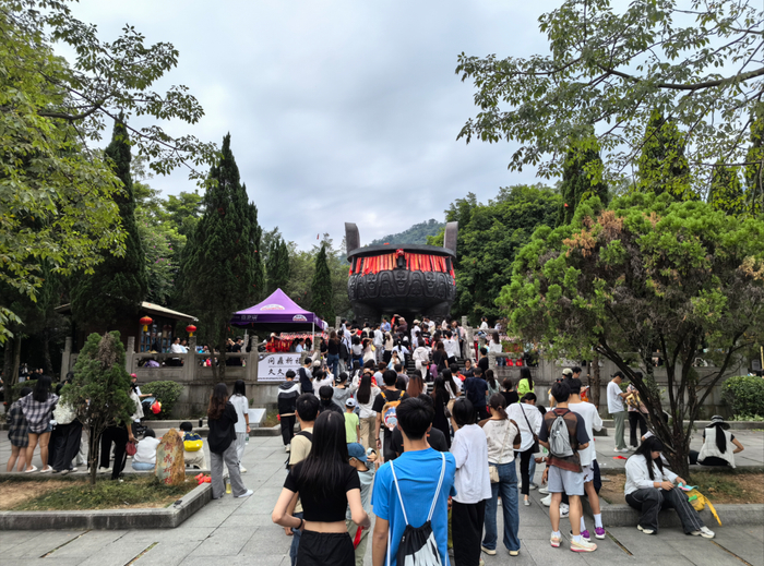 △大家围着宝鼎，高兴地往鼎里抛许愿球。肇庆市融媒体中心记者 杨丽娟 摄