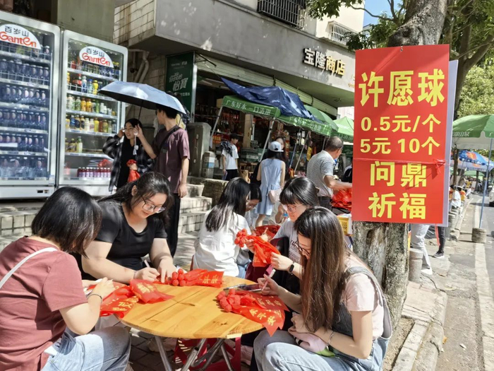 △游客在许愿球上写下愿望。肇庆市融媒体中心记者 杨丽娟 摄