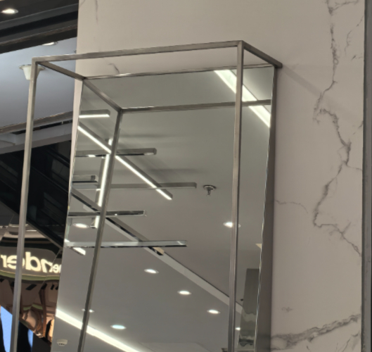 一家服装店内的镜子，因为金属边框的存在，正面看很像竖直放置，但从侧面就能看出坡度 ｜ 图源：壹读