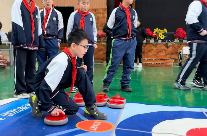 学生练习旱地冰壶的技术动作（央广网记者 刘晓祺 摄）