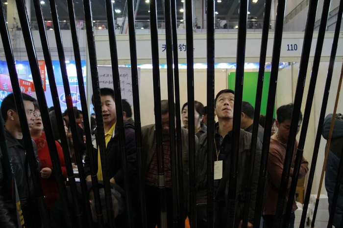 渔具展览上，人们正在钓鱼竿展位前驻足围观/图源：视觉中国