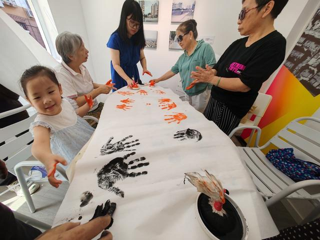 凉三小区和复旦小区居民在小巷美术馆一起按下手掌拓印。周楠摄
