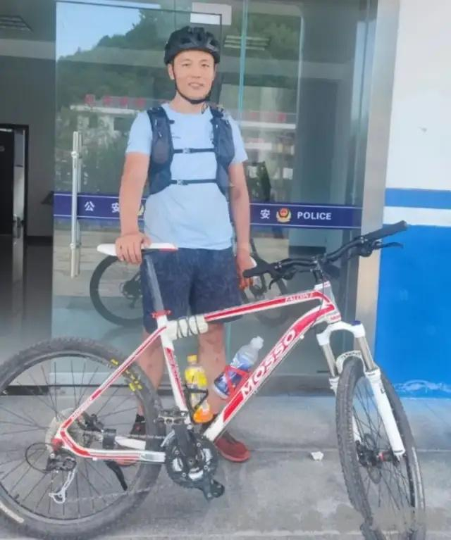 （ 2024年8月，“猛蛇过江”在鳌太线发现遇难者遗体后向警方报案，民警在派出所门口为其拍照留念 图片来源：博主猛蛇过江 ）