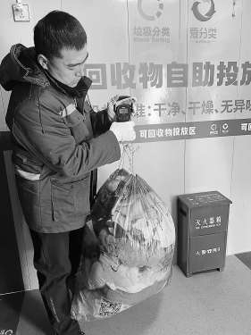 　　驿站回收员对居民交投的旧衣进行称重。记者 张楠 摄