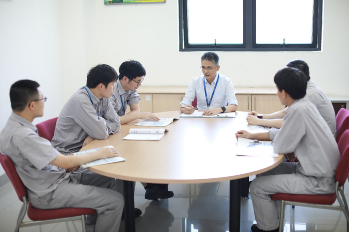 图为国家级技能大师工作室领办人邵坚铭与工作室青年骨干探讨公司科技项目推进思路。（吴舜尧摄）