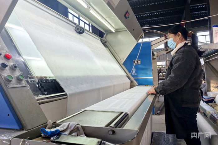 工人们正手法熟练地操作着生产设备（央广网记者  徐鹏  摄）