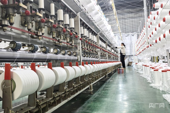 工人们正手法熟练地操作着生产设备（央广网记者  徐鹏  摄）