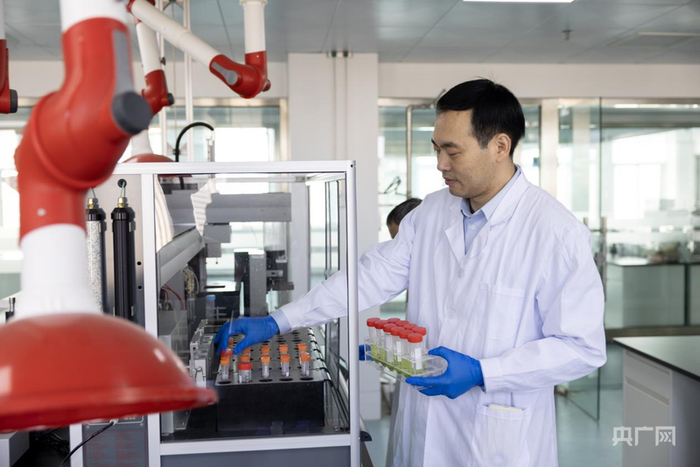 刘萌在使用入药残一体化处理器处理样品（央广网记者  夏莎  摄）