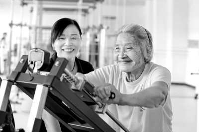     在江西省吉安市峡江县巴邱镇银福医养中心，工作人员在协助老人进行康复训练。 陈福平摄/光明图片