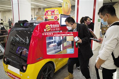 2023年3月29日，北京地铁6号线朝阳门站，一名消费者正从无人餐车中取出早餐。资料图片/新京报记者 王贵彬 摄