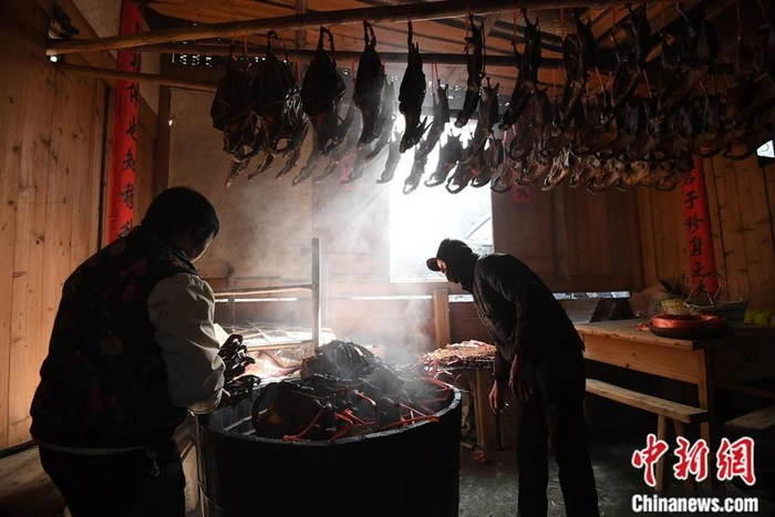 图为沙县郑湖乡一名村民在整理晾晒的板鸭。中新社记者 张斌 摄