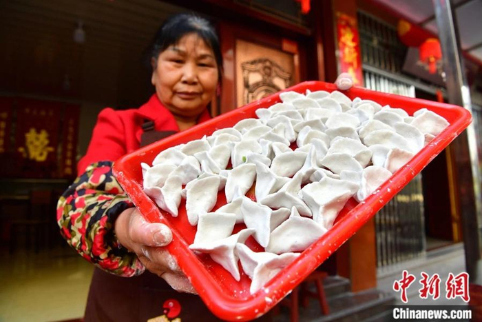 俞邦村村民展示手工制作的当地小吃芋饺。中新社记者 张斌 摄