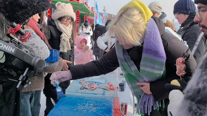 采冰节现场，外国游客体验“冰”版画（央广网记者李雪  摄）