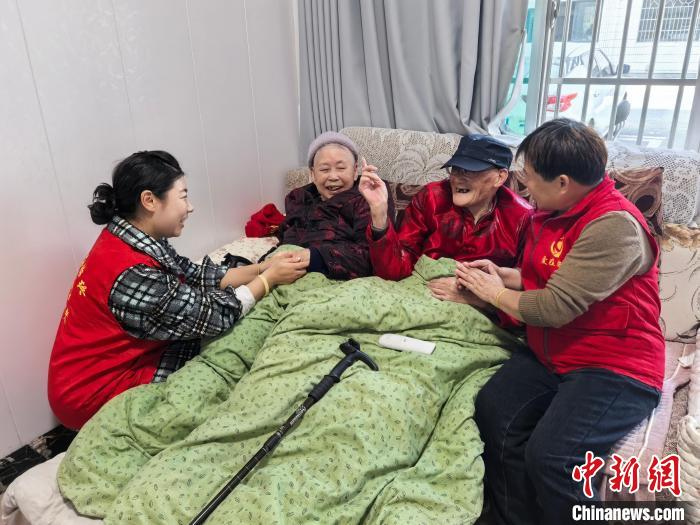  爱在始终志愿者协会的志愿者与百岁老人合影。　张雪盈 摄