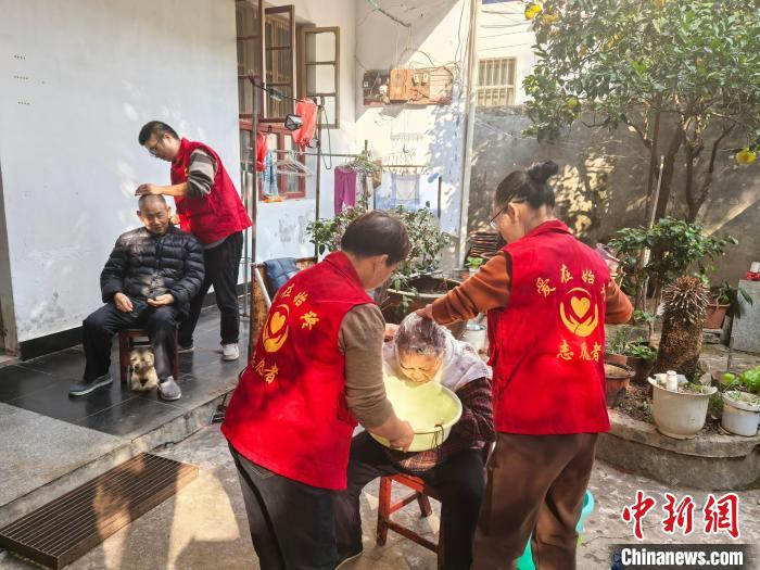  爱在始终志愿者协会的志愿者在为老人提供志愿服务。　张雪盈 摄