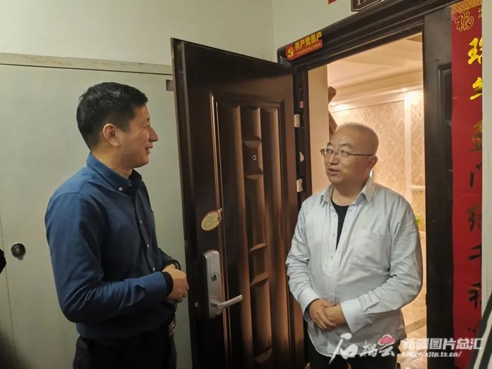 12月6日晚，田国峰（左）向乌鲁木齐市昊元上品小区业主了解小区物业服务诉求。石榴云/新疆日报记者 胡大敏摄