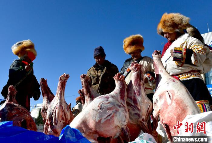 　　12月6日，西藏自治区那曲市申扎县第十八届畜产品展销会现场，民众挑选羊肉。　李林 摄