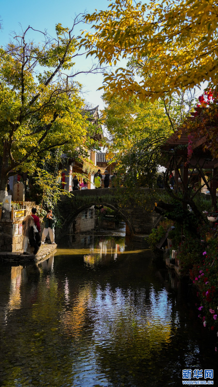 丽江古城大石桥旁，游客们拍照“打卡”，享受午后时光（12月7日摄）。新华网 刘云 摄