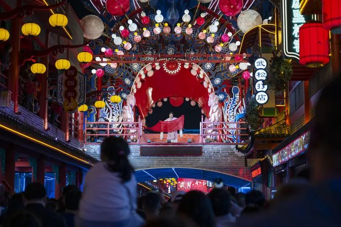 10月12日，游客在竹溪县武陵不夜城观看表演。新华社记者 伍志尊 摄