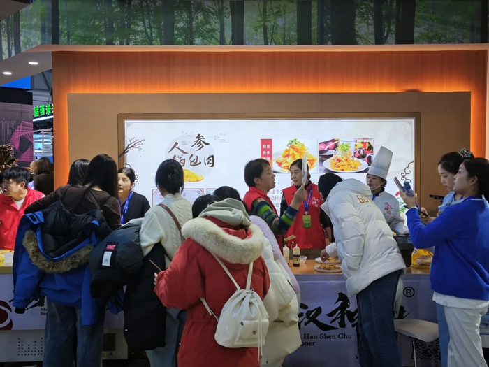 在2024长春国际医药健康产业博览会上，参观者品尝人参锅包肉。新华社记者胡戈 摄