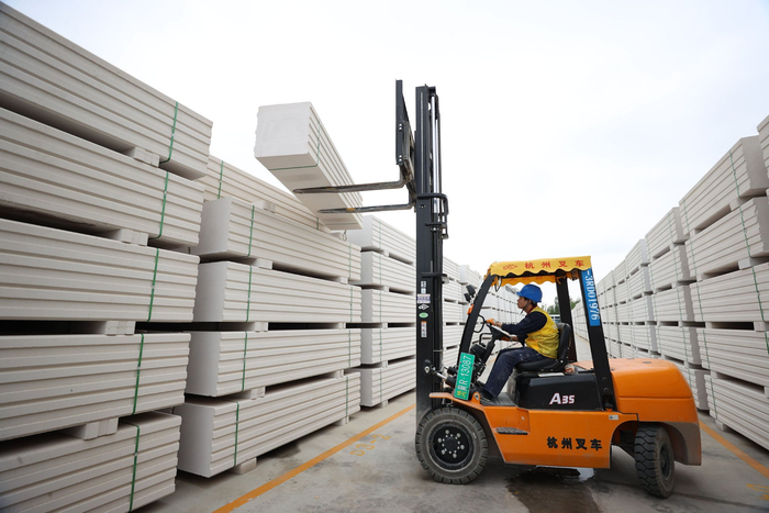 图为文安县玖顺建材有限公司产品码放区，工人正在码放成品。