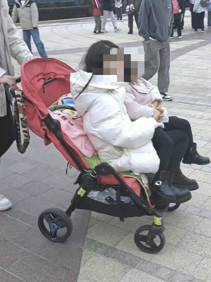 12月10日，大人与小孩混乘大载重儿童车进入上海迪士尼乐园。新京报贝壳财经记者俞金旻摄