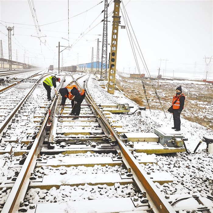银川车务段工作人员清扫铁路道岔积雪。