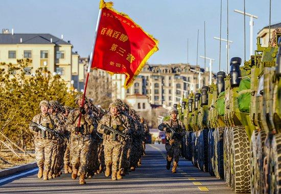 三营官兵手擎战旗、高喊口号奔赴训练场。张永进/摄