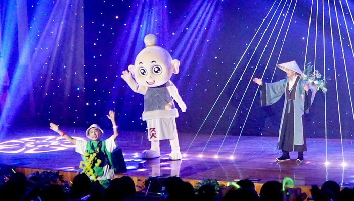     舞台剧《药圣》中，灸童（中）与台下观众互动。本报记者  秦宇龙摄