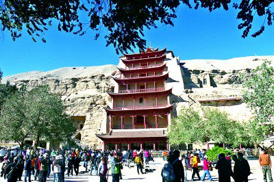 甘肃敦煌，游客在莫高窟参观。张晓亮摄/光明图片