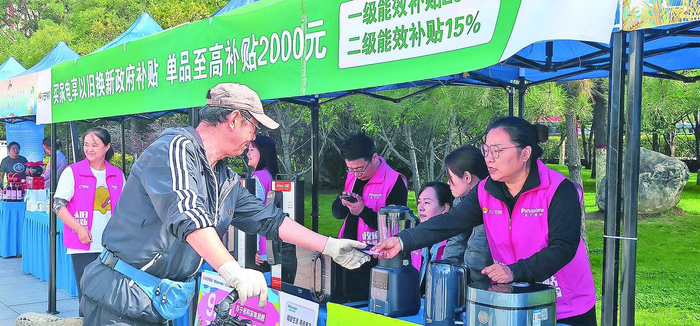 家电企业工作人员向市民讲解以旧换新政策。张慧慧 摄