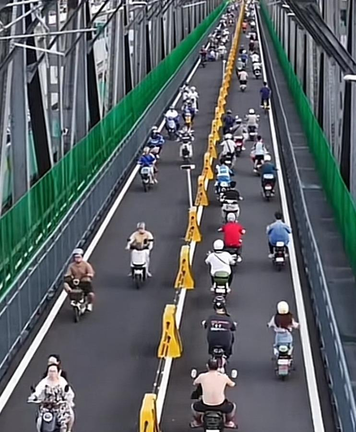 路上骑着电动自行车的人（图源：媒体报道截图）