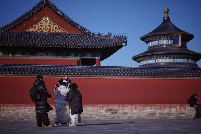 12月13日，天坛公园，商拍摄影师在给顾客看照片拍摄效果。新京报记者 薛珺 摄