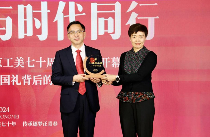 　　▲ 北京市商务局副局长卢慧玲为北京工美集团董事长段体玉颁发七十年生辰牌