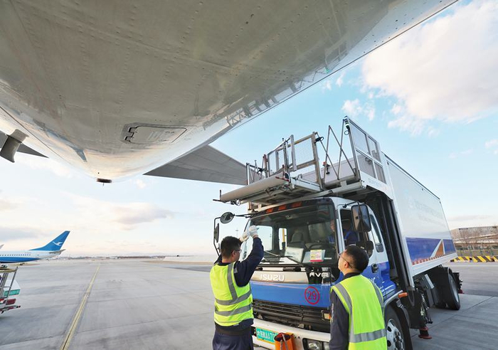 12月6日，北京大兴国际机场，工作人员指挥航食车与飞机对接。新京报记者 陶冉 摄