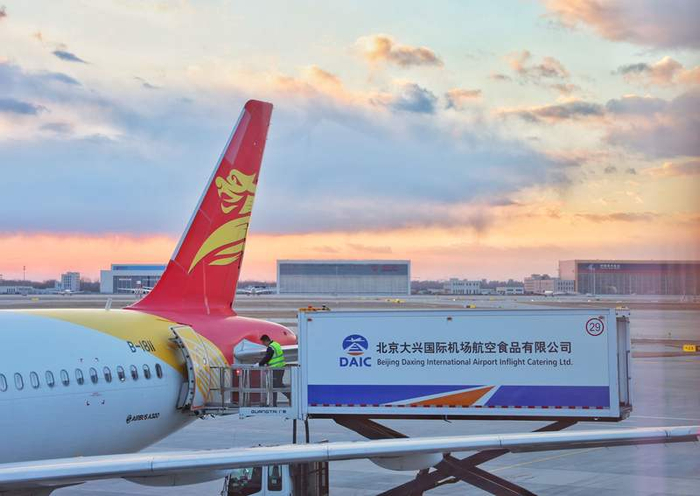 12月6日，北京大兴国际机场，工作人员将机上餐食通过推车送入机舱。新京报记者 陶冉 摄