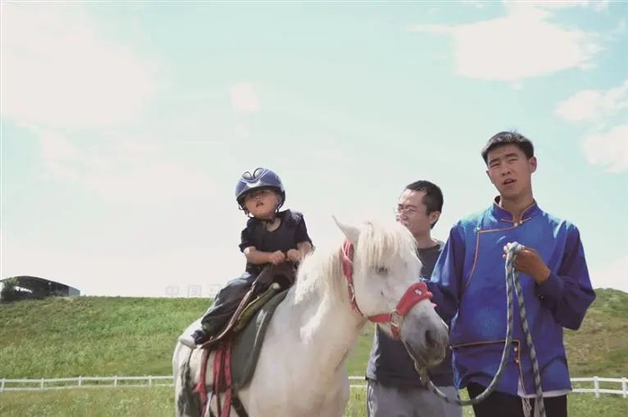 图为游客正在丰宁坝上草原体验骑马。