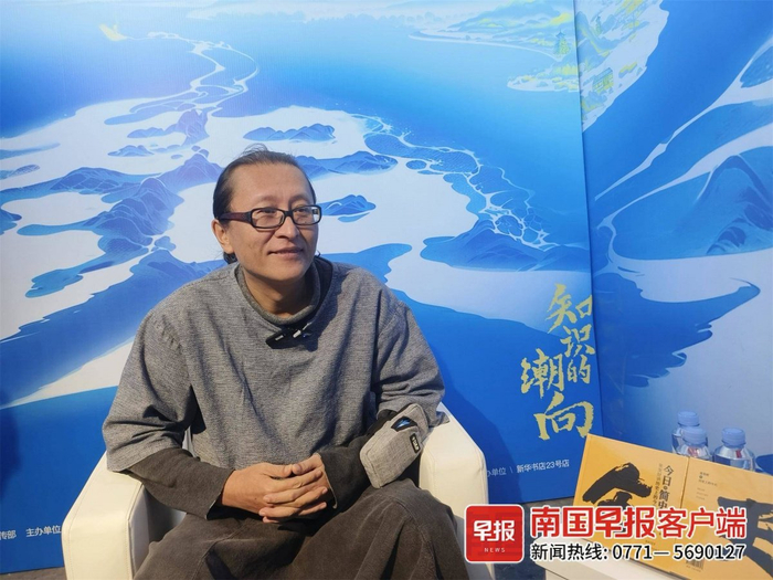 ▲张发财向记者介绍书中的有趣内容。记者 李慧子 摄