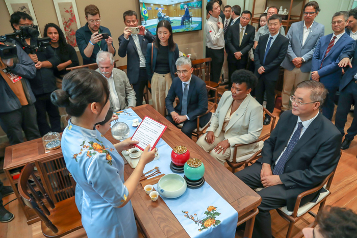 图为曾服务中印东湖茶叙的八马首席“茶仙子”姜雨桐向中国驻巴西大使祝青桥、巴西文化部部长梅内塞斯等嘉宾介绍中国茶