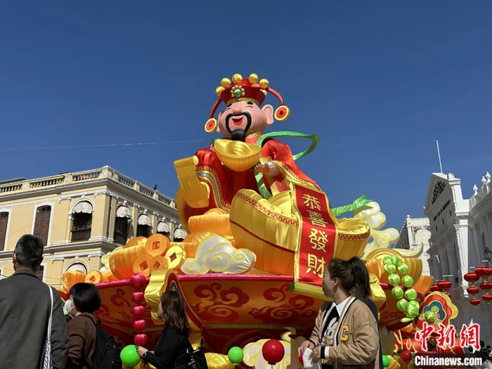 2023年春节期间，在澳门市中心议事亭前地广场中央，大型财神装饰吸引了许多游客。中新社记者 李亚南 摄