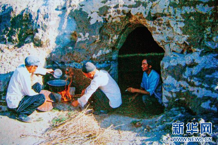   1983年，“六老汉”一代治沙人在“地窝子”生火做饭（资料图片）。八步沙林场供图