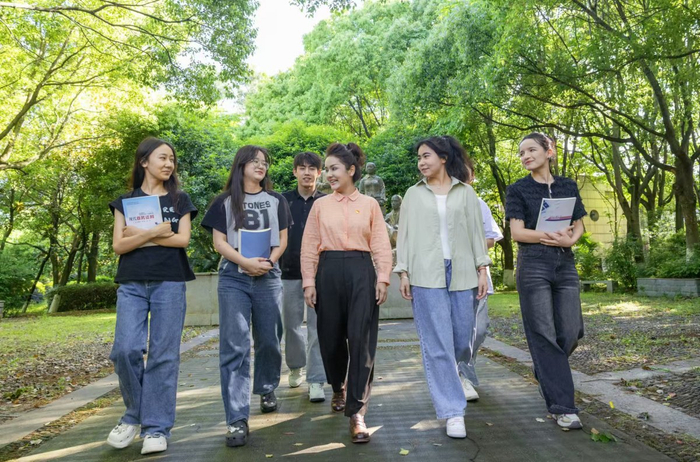 米娜瓦尔·艾力（中）在校园里和学生谈心。