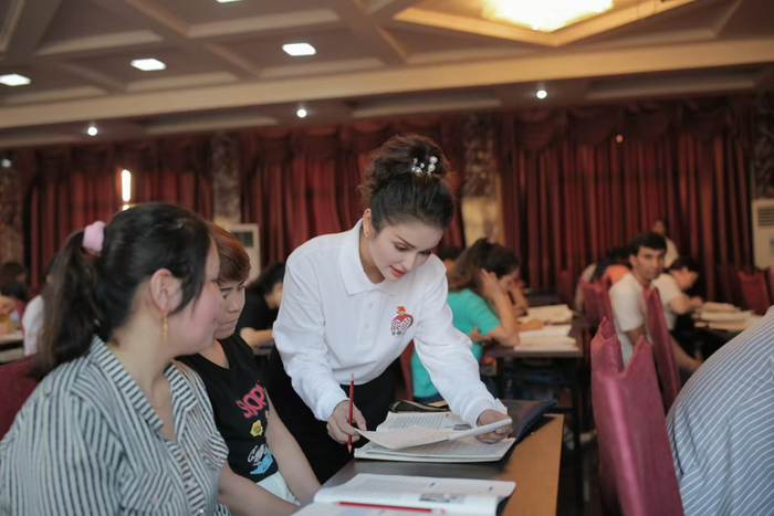 米娜瓦尔·艾力（右一）为来浙民族群众进行通用语言文字培训。