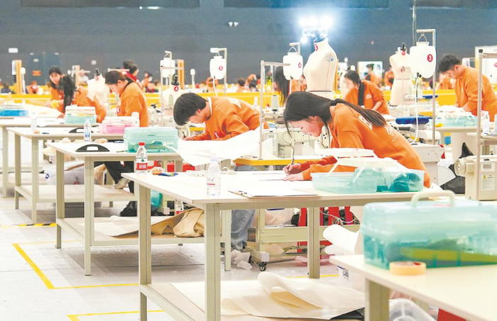 时装技术比赛现场，选手正在画设计图。